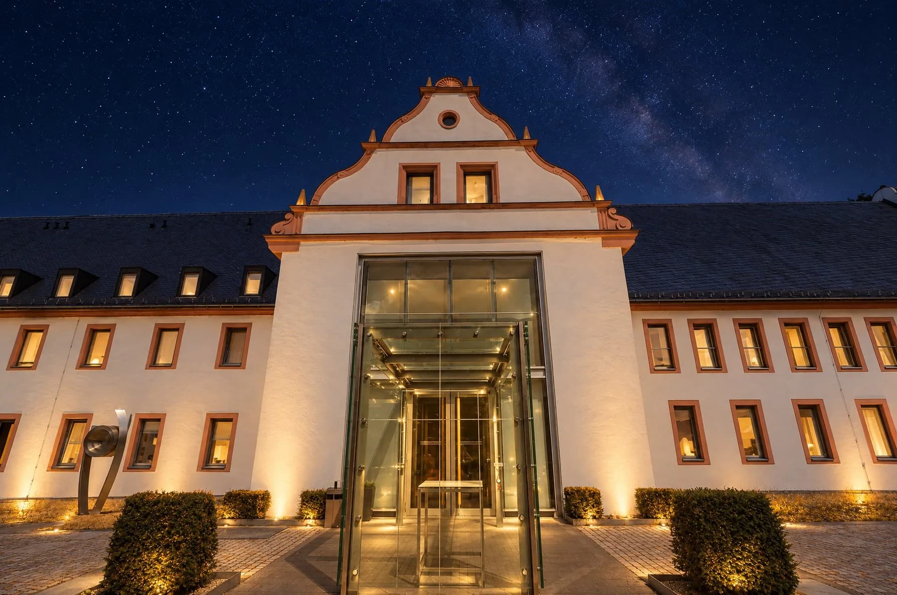 Eingangsgebäude mit Glasvorbau bei Nacht